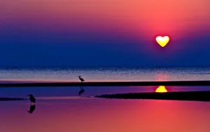 A Radiant Heart Silhouette In The Sunset Sky Wallpaper