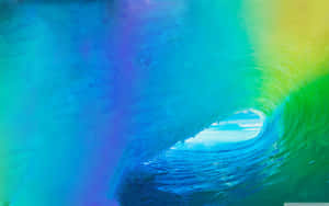 A Rainbow Colored Wave In The Ocean Wallpaper