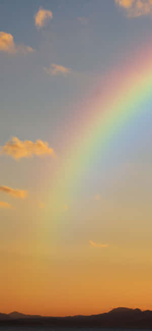 A Rainbow Is Seen Over A Body Of Water Wallpaper