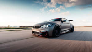 A Red Bmw Sports Car Parked In Front Of A City Skyline Wallpaper