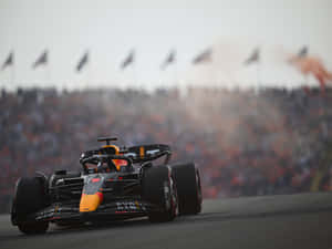 A Red Bull Racing Car Driving Down A Track Wallpaper
