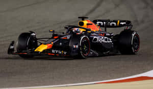 A Red Bull Racing Car Is Driving On A Track Wallpaper