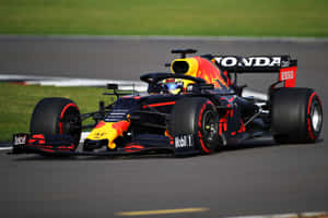 A Red Bull Racing Car Is Driving On A Track Wallpaper