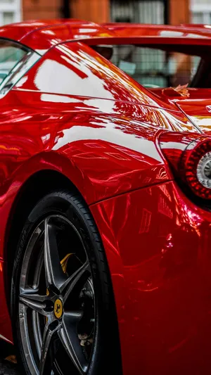 A Red Car Against The Backdrop Of A Stunning Sunset Wallpaper