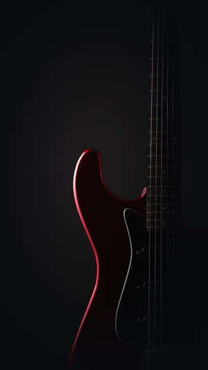 A Red Electric Guitar Is Shown Against A Black Background Wallpaper