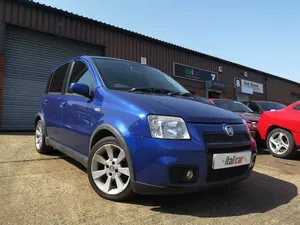 A Red Fiat Panda On A Scenic Road In The Countryside Wallpaper