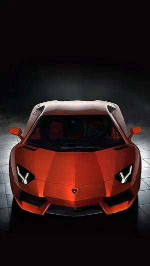 A Red Sports Car Is Shown In A Dark Room Wallpaper