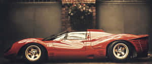 A Red Sports Car Parked In Front Of A Building Wallpaper