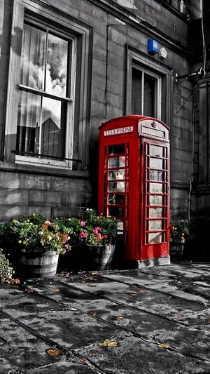 A Red Telephone Booth In Front Of A Building Wallpaper