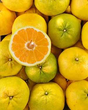 A Refreshing Display Of Whole And Sliced Ugli Fruits Wallpaper