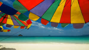 A Relaxing Day At The Beach With A Colorful Beach Umbrella Wallpaper