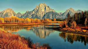 A River Surrounded By Mountains In Autumn Wallpaper