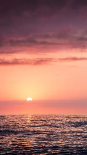 A Romantic Orange Sunset Over The Beach Wallpaper