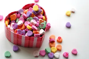 A Romantic Valentines Day Scene With Lovebirds Perched Atop Roses. Wallpaper