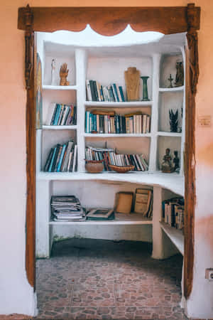 A Room With A Book Shelf And Books Wallpaper