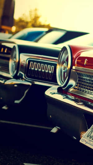 A Row Of Classic Cars Parked In A Parking Lot Wallpaper