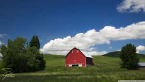 A Scenic Country Landscape Of Rolling Green Hills Complemented By The Beauty Of A Cozy Farmhouse. Wallpaper