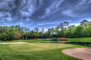 A Scenic Golf Course Surrounded By Trees. Wallpaper