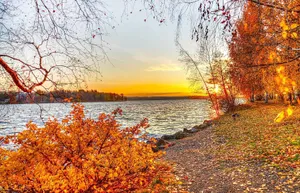 A Scenic View Of A Farmhouse Surrounded By Vibrant Autumn Foliage Wallpaper