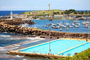 A Scenic View Of The Coastline Of Wollongong With The Lighthouse At The Center, During Sunset Wallpaper