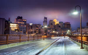 A Scenic Winter Cityscape During A Peaceful Snowfall Capturing The Essence Of The Season. Wallpaper