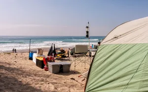 A Serene Beach Campsite During Sunset Wallpaper