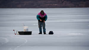 A Serene Ice Fishing Getaway On A Frozen Lake Wallpaper