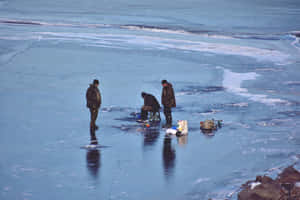 A Serene Ice Fishing Scene At A Picturesque Winter Lake Wallpaper