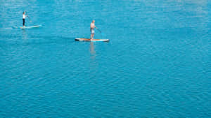 A Serene Paddleboarding Adventure On A Calm Lake Wallpaper