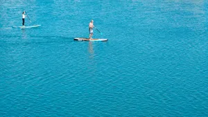 A Serene Paddleboarding Adventure On A Calm Lake Wallpaper