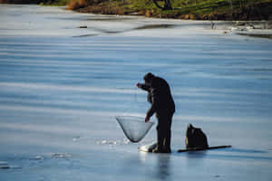 A Serene Winter Day At The Ice Fishing Hole Wallpaper