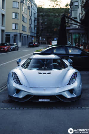 A Silver Sports Car Parked On The Side Of The Street Wallpaper