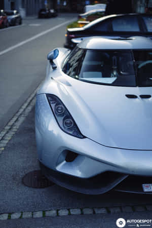 A Silver Sports Car Parked On The Side Of The Street Wallpaper