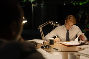 A Skilled Detective Scrutinizing Evidence For A Complex Case Wallpaper