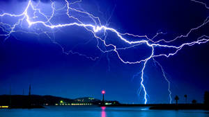 A Sky Full Of Wonder As Lightning Strikes From Above Wallpaper