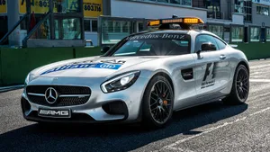 A Sleek And Modern Safety Car Leading The Race On The Track Wallpaper