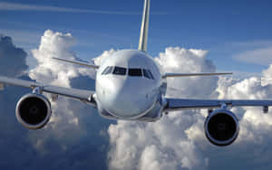 A Sleek And Powerful Jumbo Jet Flying Across The Sky Wallpaper