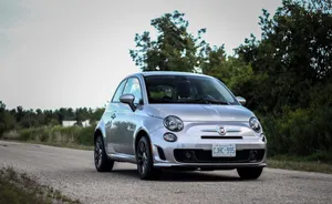 A Sleek And Stylish Red Fiat 500 Parked On A City Street Wallpaper