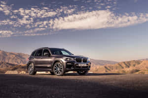 A Sleek Black Bmw X3 With A Dramatic Background Wallpaper