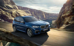 A Sleek Bmw X3 Cruising On An Open Road Under A Bright Blue Sky. Wallpaper