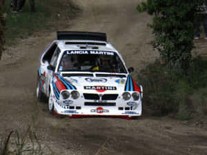 A Sleek, Elegant Lancia Automobile Driving On A Winding Road Wallpaper