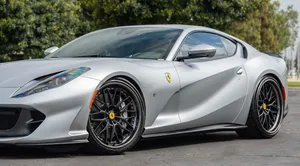 A Sleek Red Beauty, The Ferrari 812 Superfast Speeds Past The Open Road And Awes The Onlookers. Wallpaper