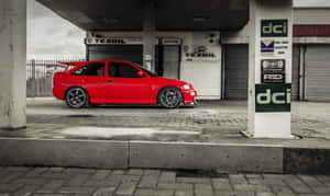 A Sleek Red Ford Escort On Display Wallpaper