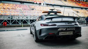 A Sleek Safety Car Leading The Race On A High-speed Track Wallpaper