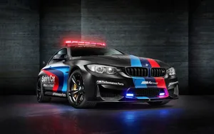 A Sleek Safety Car Leads The Race On A Picturesque Day Wallpaper