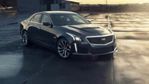 A Sleek Silver Cadillac Ats In Front Of A Modern Building Wallpaper