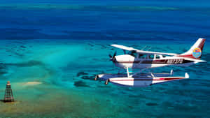 A Small Plane Flying Over The Ocean Wallpaper