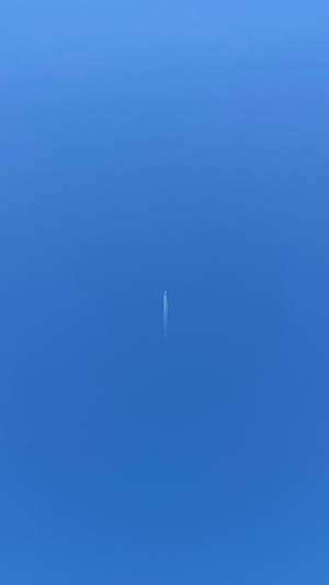 A Small Plane Trails A Ribbon Of Cloudy Vapor In The Sky Wallpaper