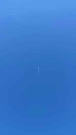 A Small Plane Trails A Ribbon Of Cloudy Vapor In The Sky Wallpaper
