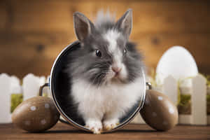 A Small Rabbit Sitting In A Basket With Easter Eggs Wallpaper